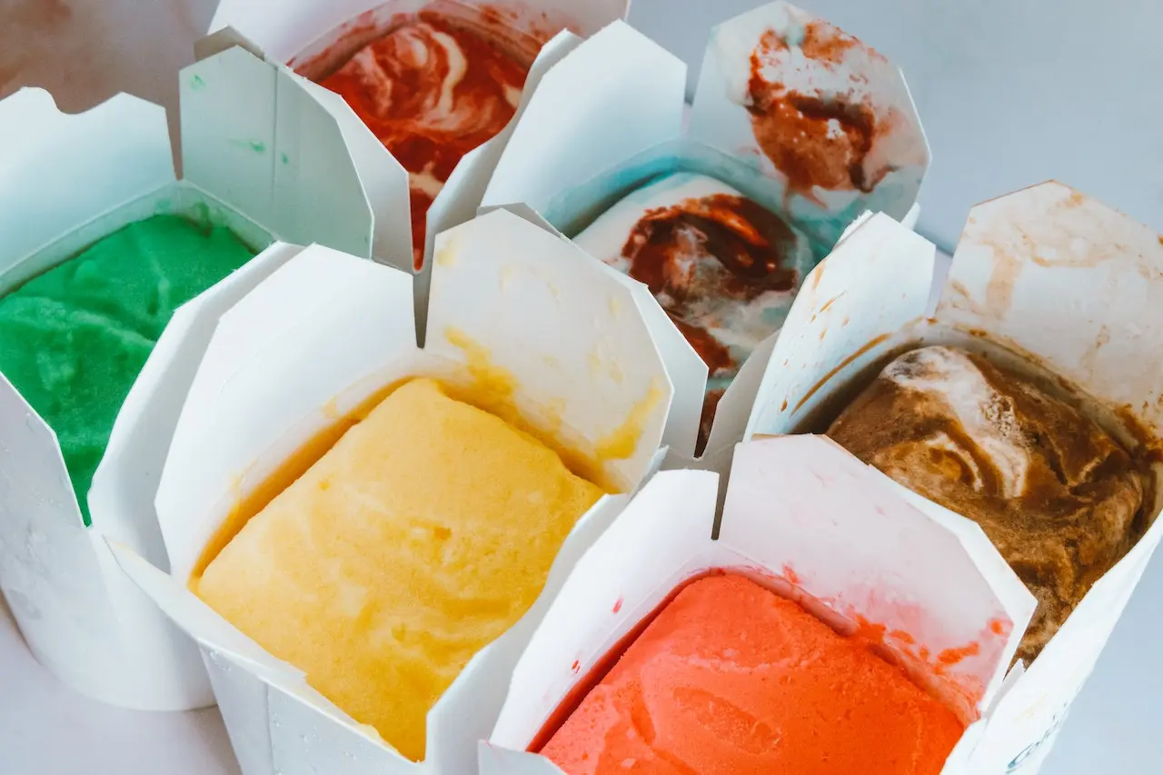 بستنی های میوه ای و شکلاتی که در کنار هم قرار دارند و داخل کاسه های کاغذی ریخته شده اند